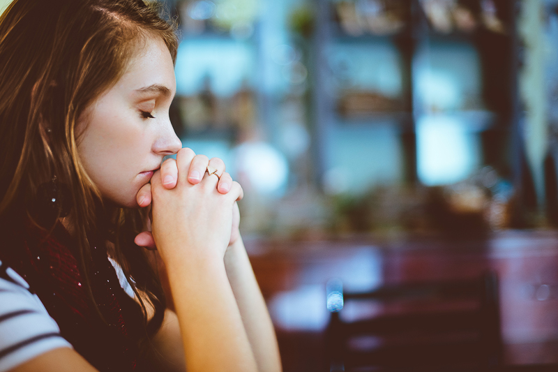 Theologiestudium: junge Frau betet