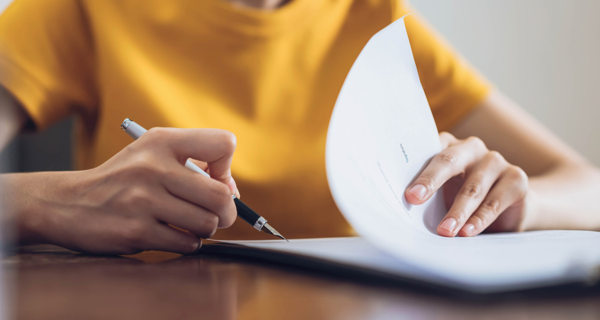 Woman signing document and hand holding pen putting signature at paper, order to authorize their rights.